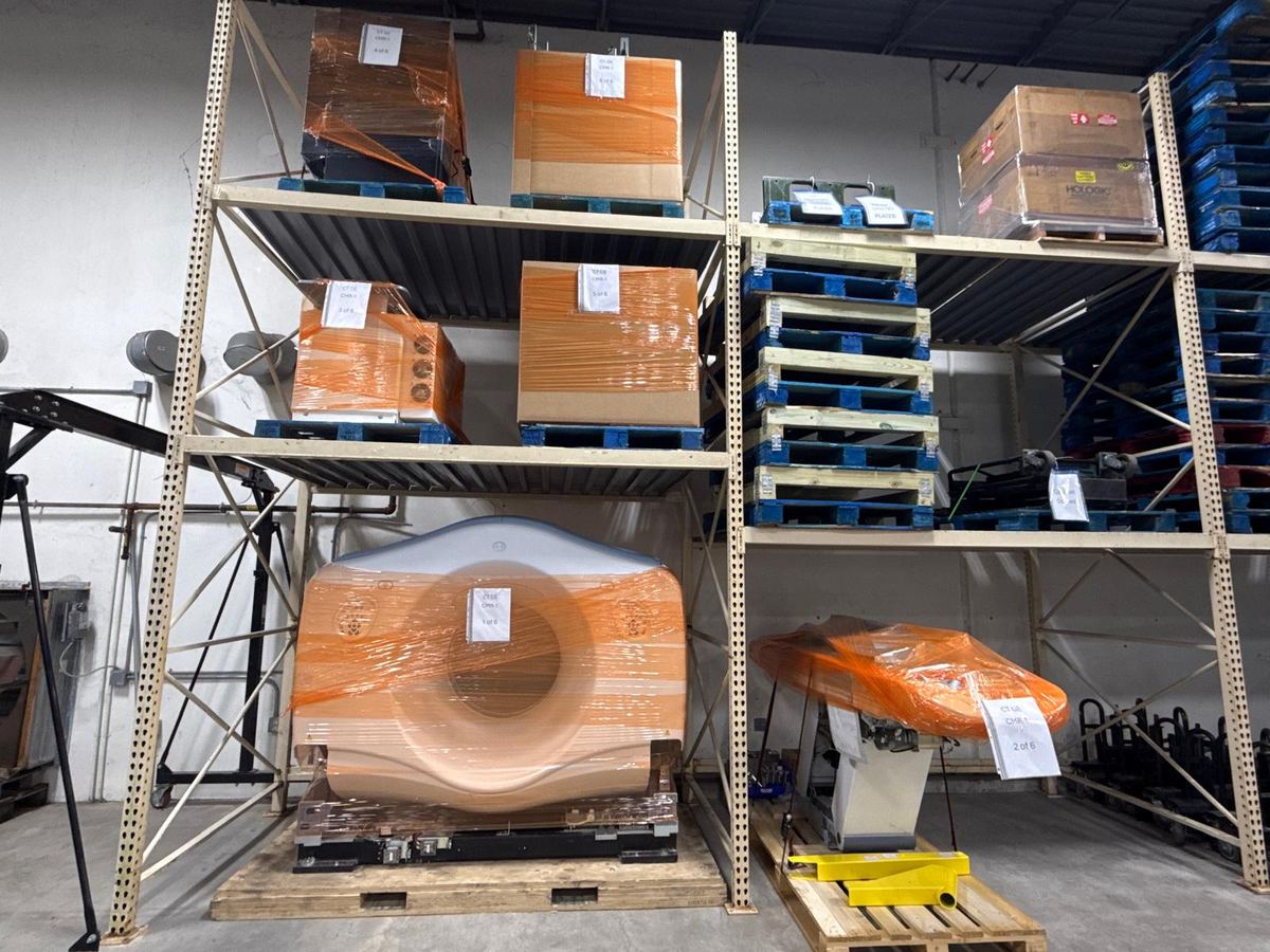 Scanner components and crated parts racked in the climate-controlled warehouse