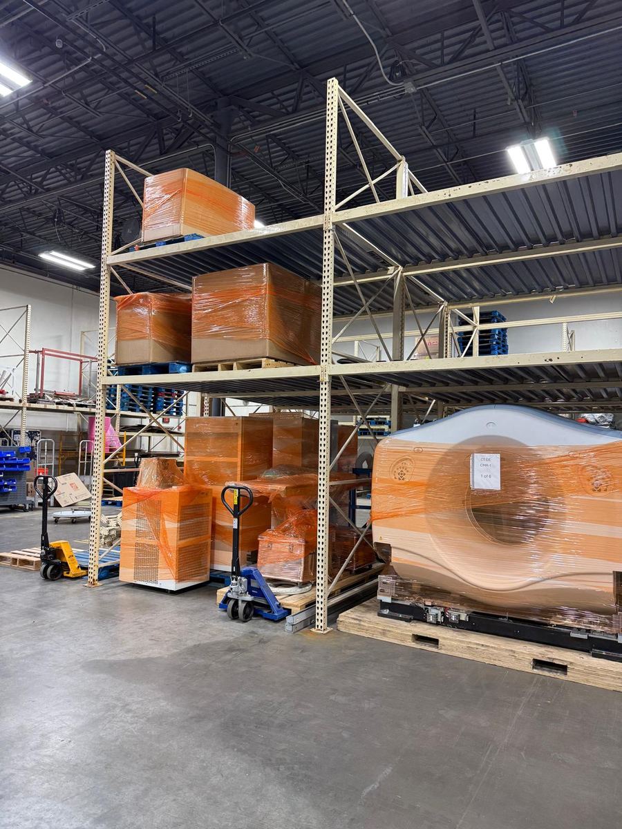 Warehouse racking holding a scanner bore and crated components awaiting delivery