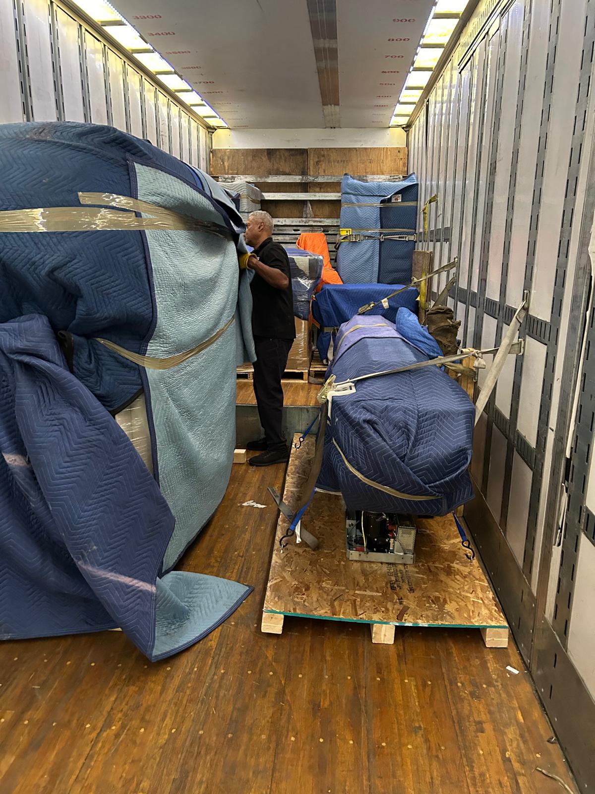 Blanket-wrapped medical equipment loaded and secured inside a trailer
