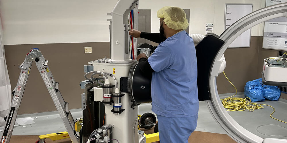 Technician installing imaging equipment in a hospital suite